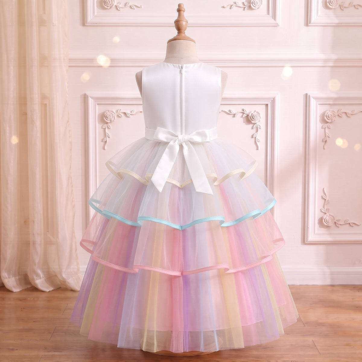 Back view of the white unicorn gown on a mannequin: center back zipper and white satin bow