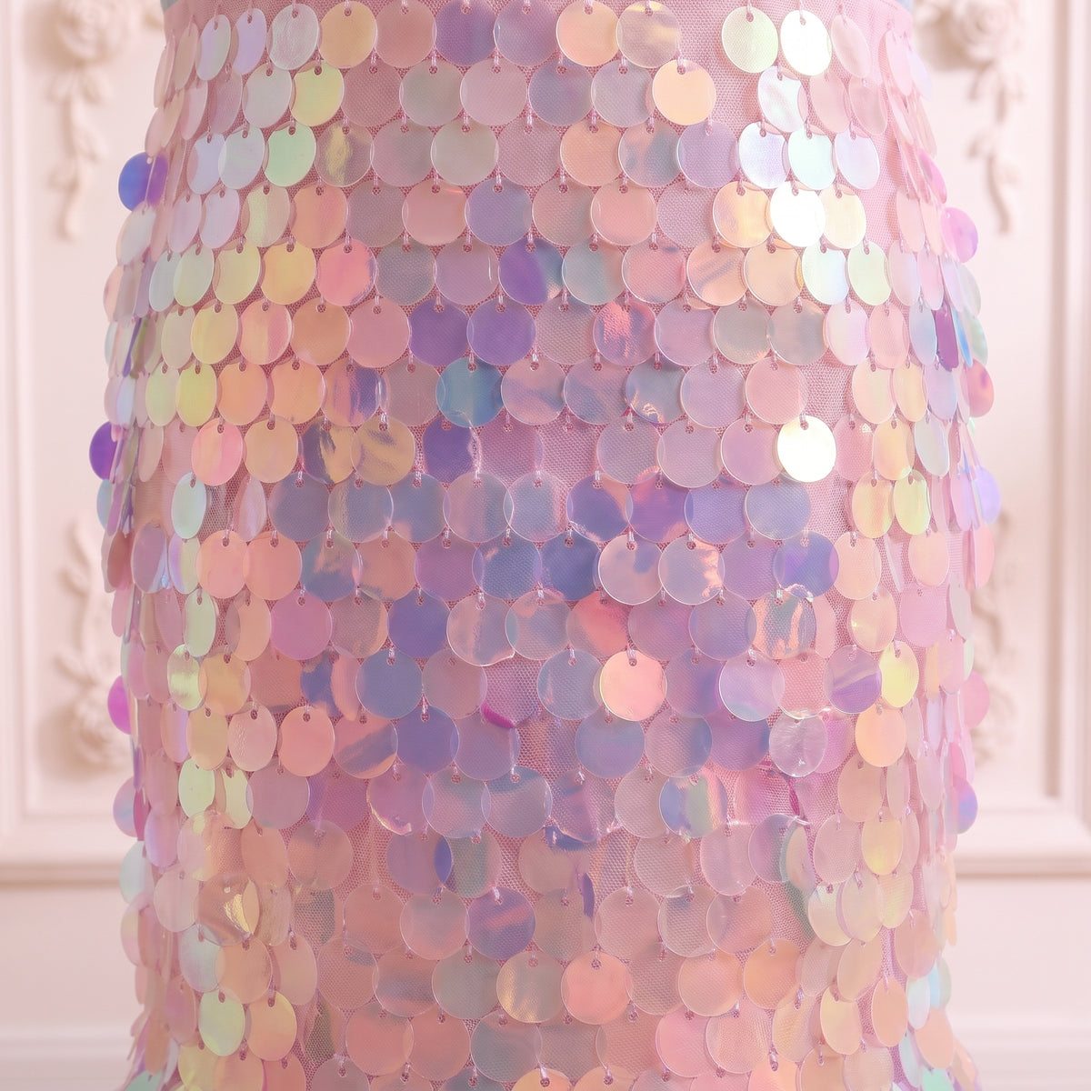 Close up of the overlapping round paillette sequins in aqua, lilac and pink on the skirt