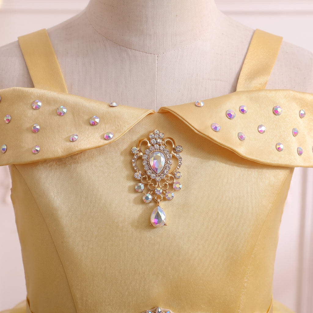 Close up of the pearl-dotted off-shoulder collar and gold filigree teardrop brooch on the yellow satin bodice