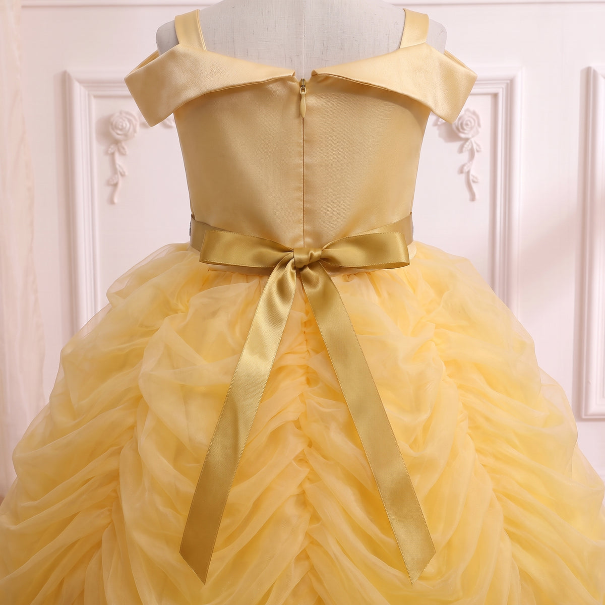 Back view of the Belle ball gown on a mannequin: zip closure and satin sash bow over the tulle swags