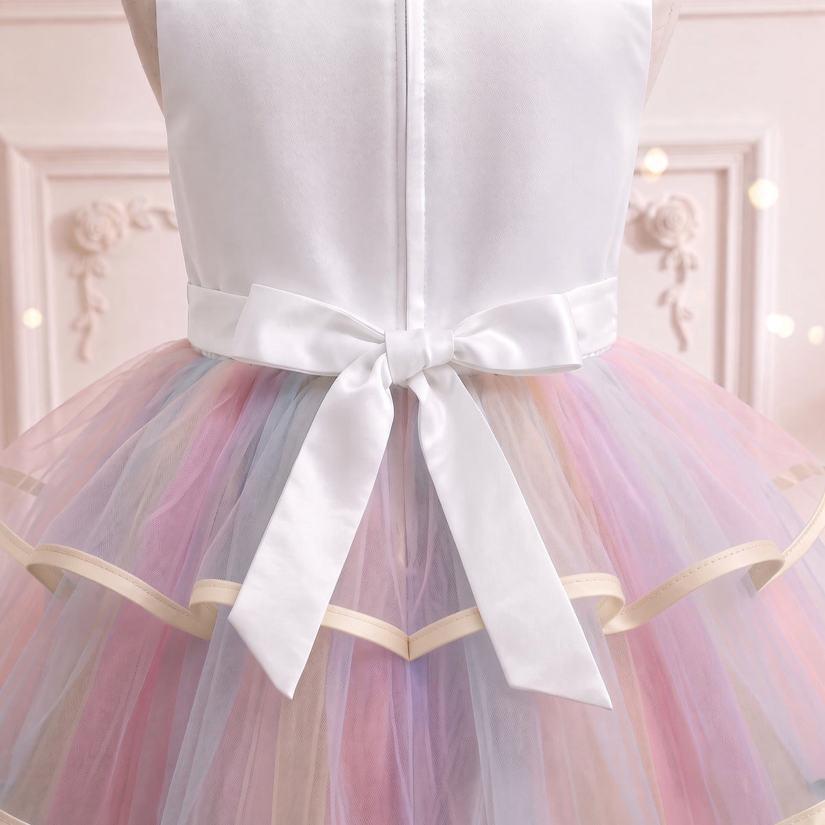 Close up of the white satin bow with long streamers at the back waist
