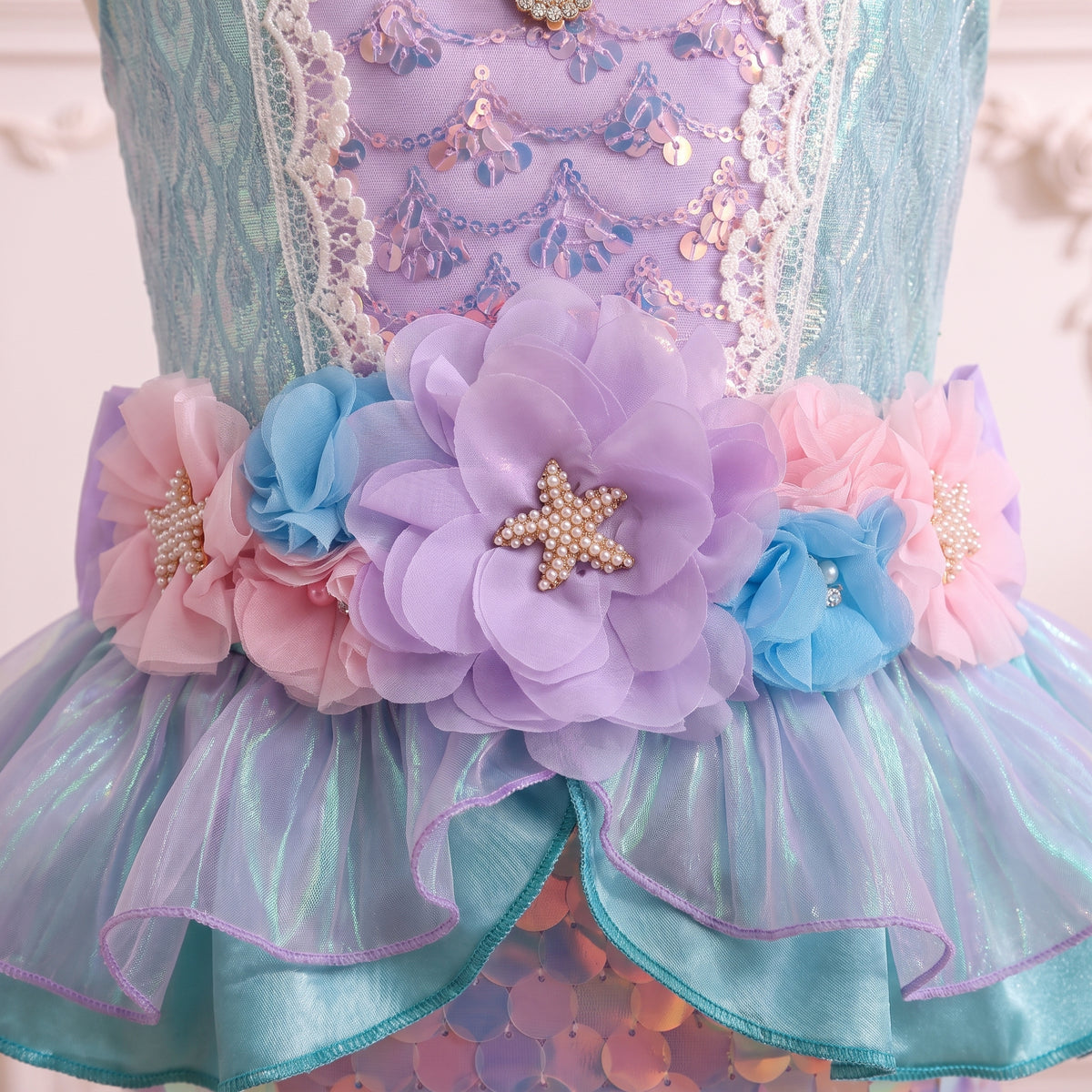 Close up of the pink, lilac and blue organza flowers with starfish centers at the waist