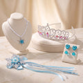 Ice Queen Jewelry Set flat lay: snowflake pendant necklace, rhinestone tiara, aqua heart clip-on earrings and glitter snowflake wand