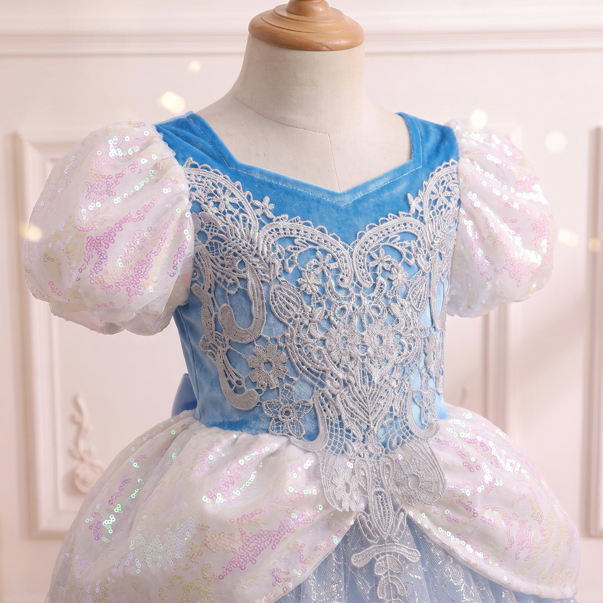 Close up of the royal blue bodice with ornate silver lace applique and sequin puff sleeves