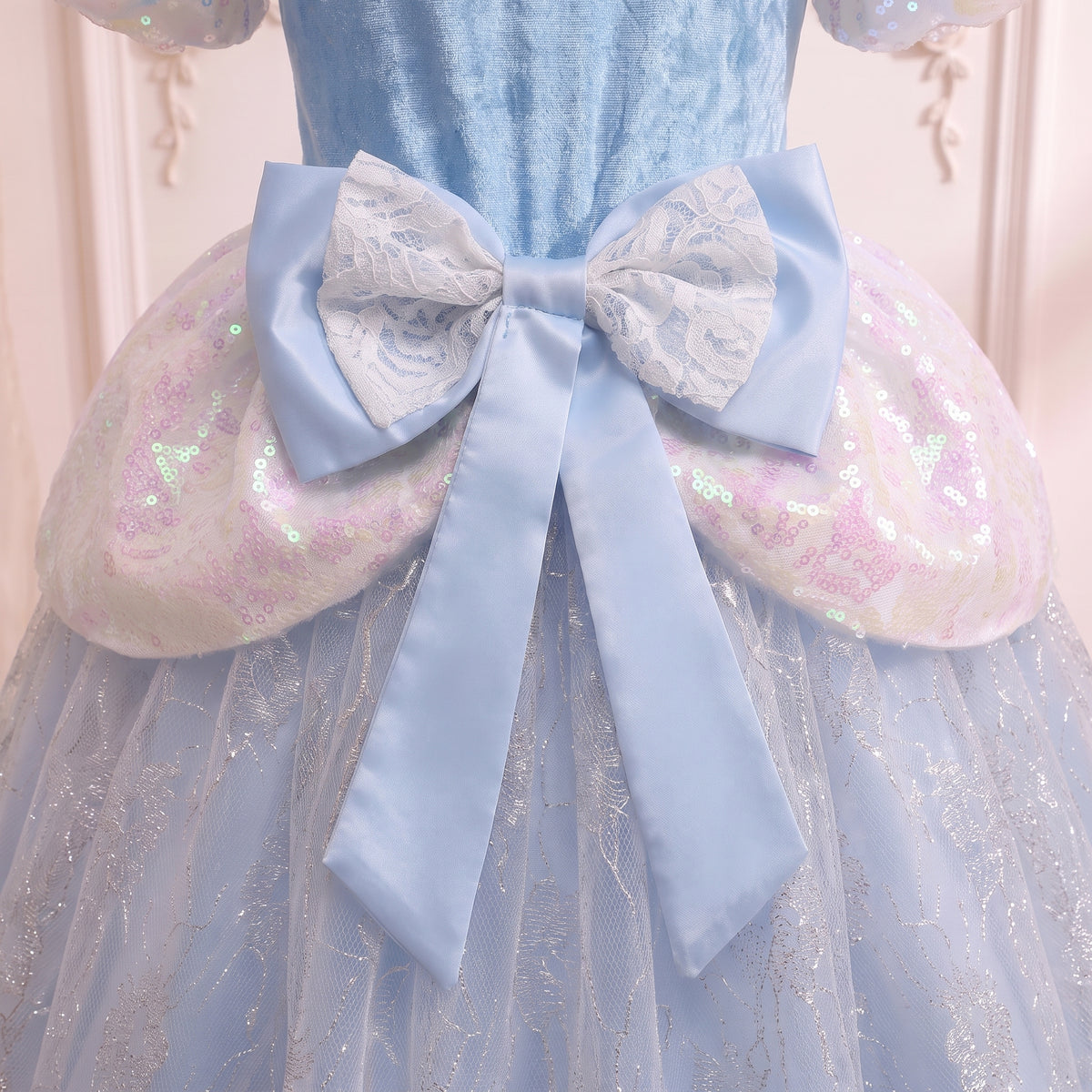 Close up of the wide pale blue back bow over the iridescent sequin peplum