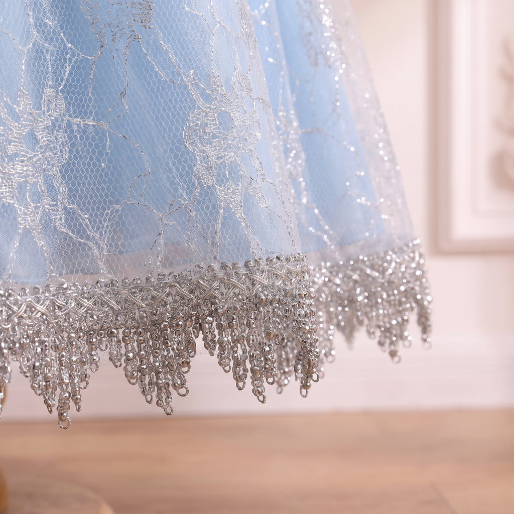 Close up of the scalloped silver lace hem on the pale ice blue skirt
