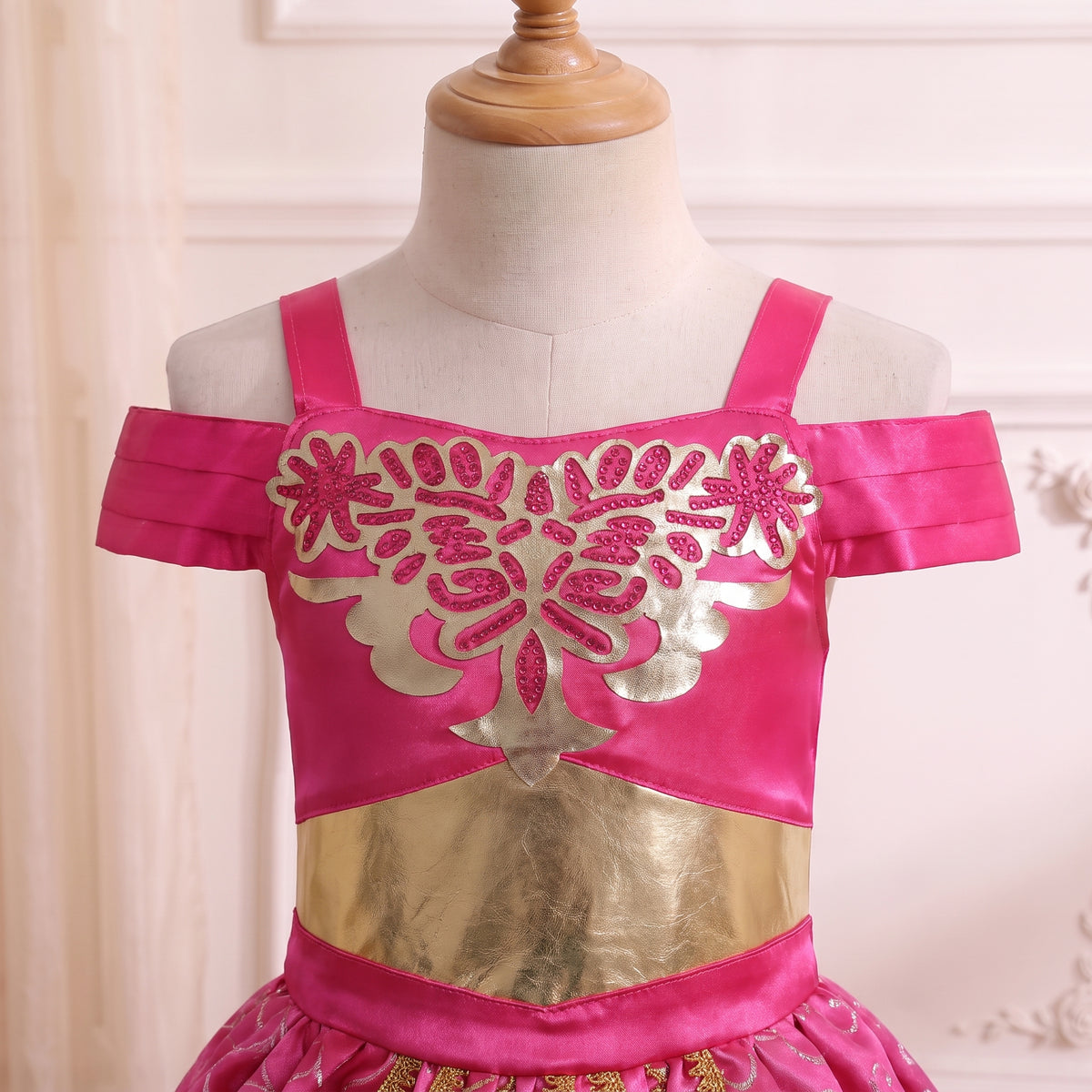 Close up of the gold cut-out damask applique bodice with pink crystals and gold lame waistband