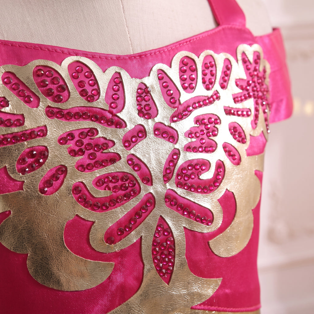 Macro close up of the gold applique studded with pink crystals