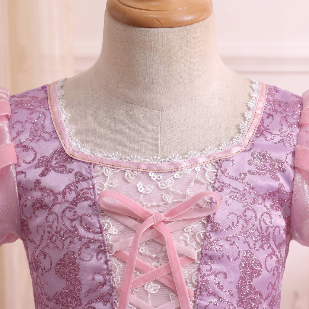 Close up of the Rapunzel gown's square neckline with scalloped silver beaded lace and a pink ribbon bow