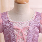 Close up of the Rapunzel gown's square neckline with scalloped silver beaded lace and a pink ribbon bow