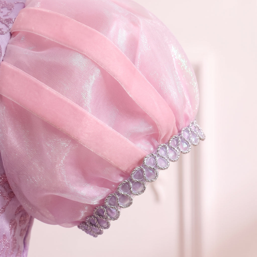 Close up of a sheer pink puff sleeve with ribbon stripes and a silver sequin cuff on the Rapunzel gown