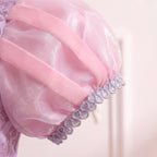 Close up of a sheer pink puff sleeve with ribbon stripes and a silver sequin cuff on the Rapunzel gown