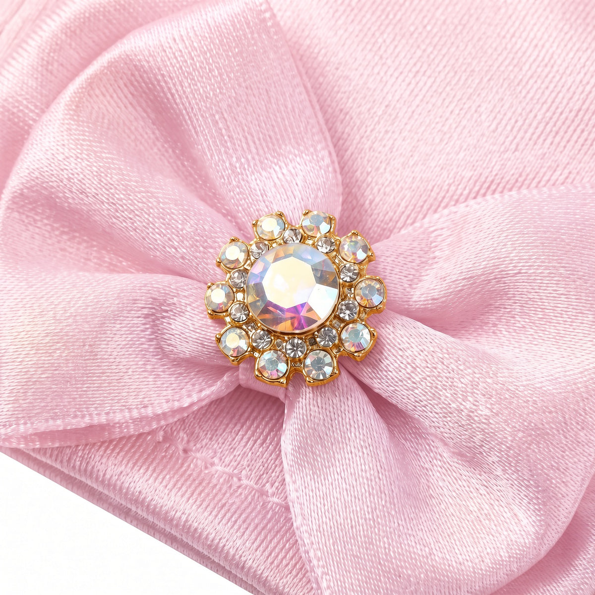 Close up of the rhinestone button on the pink satin glove bow