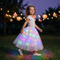 Girl wearing the Rainbow LED Petticoat glowing in pink, aqua, green, blue and gold at dusk