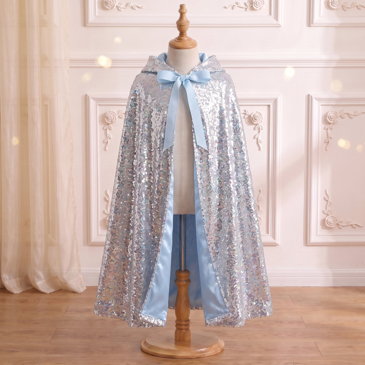 Front view of the Silver Sequined Cape on a mannequin: ice blue satin lining and ribbon ties