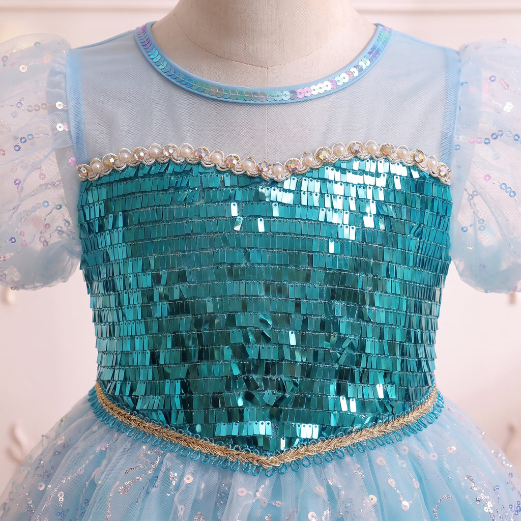 Close up of the teal sequin bodice, pearl-beaded edge and sheer illusion yoke