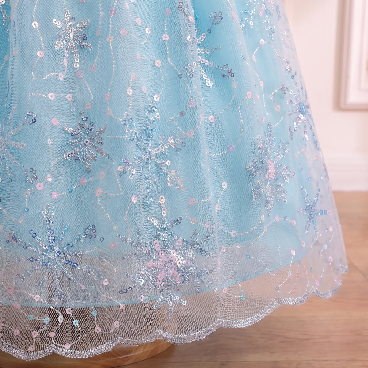 Close up of the scalloped, sequin-edged hem of the snowflake tulle skirt