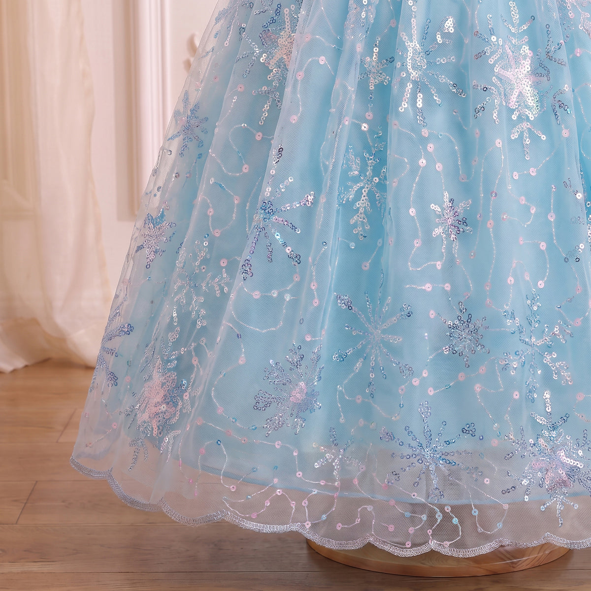 Close up of the ice blue tulle skirt embroidered with iridescent sequin snowflakes