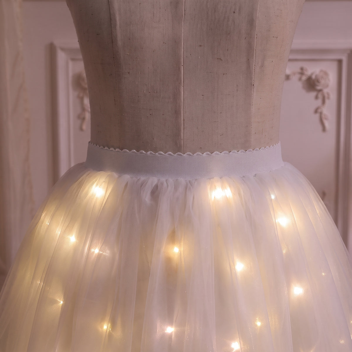Close up of the flat white waistband and warm white lights through the tulle