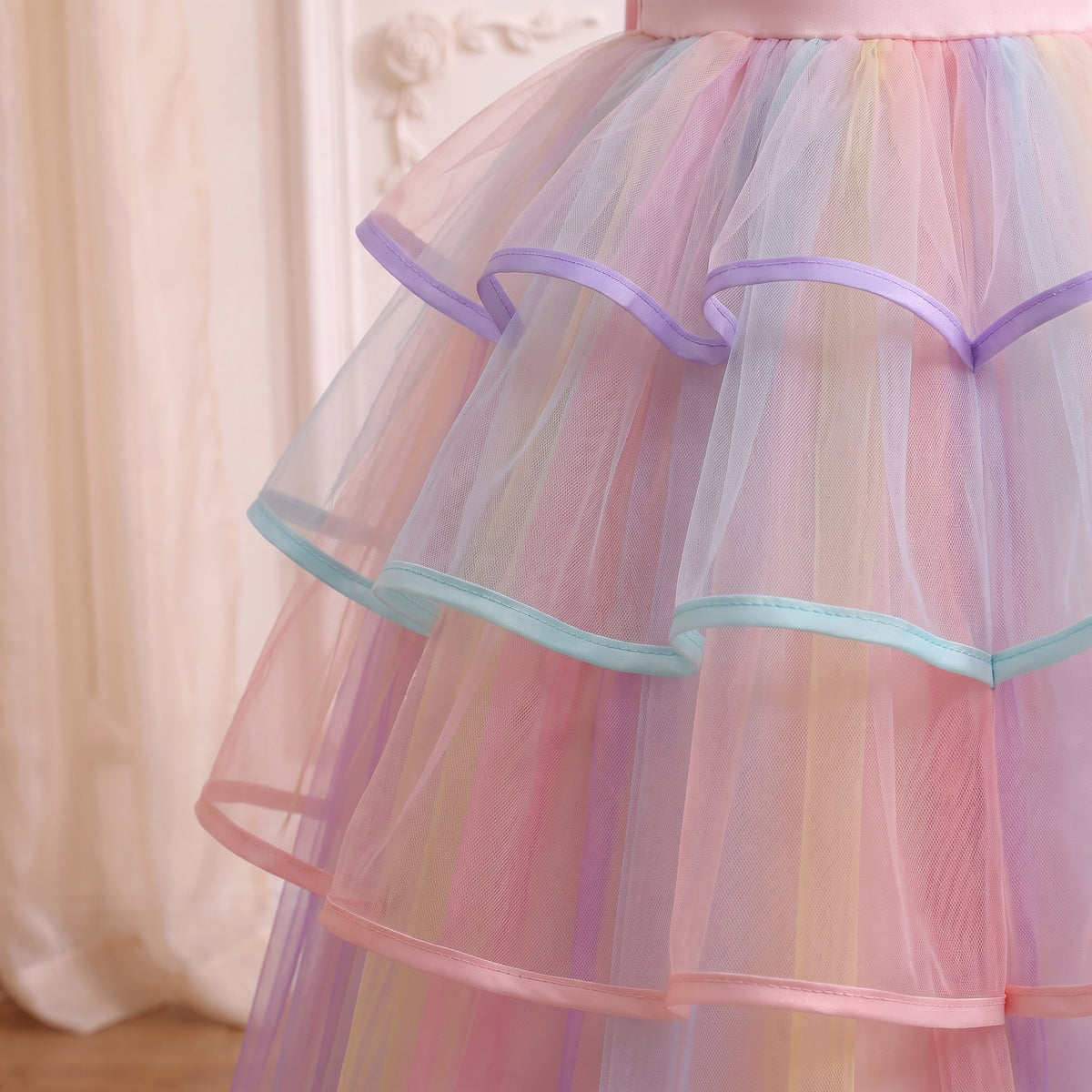 Close up of the three ribbon-edged ruffle tiers over rainbow striped tulle