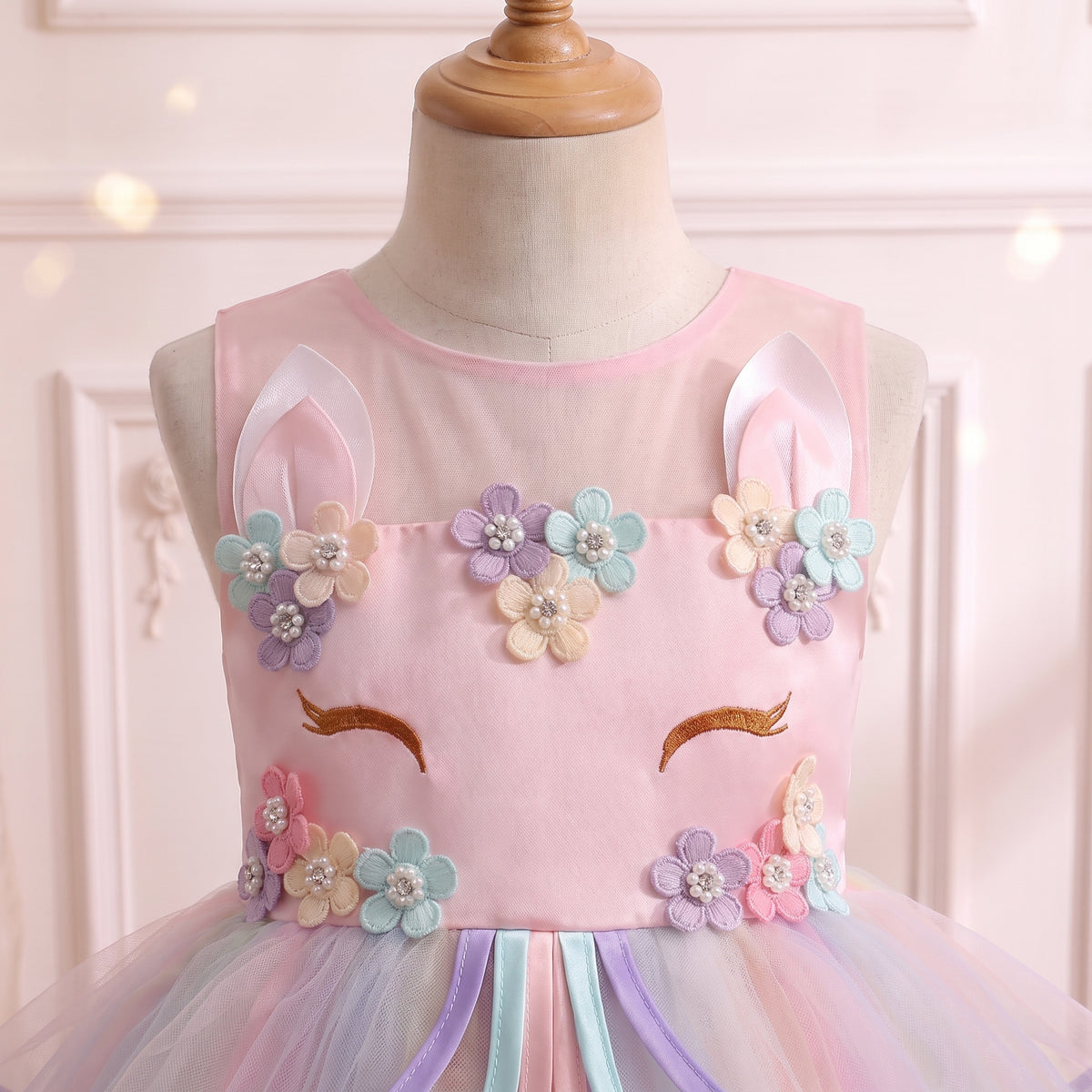 Close up of the sleeveless pink bodice with standing unicorn ears, sparkle straps and flower crown